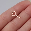 Macro shot of rose gold heart-shaped key pendant showing mini size and polished finish - Key / Rose Gold