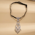 Detalle de collar de corbata plateado con diamantes de imitación sobre fondo champán - Estilo de Borla con Diamantes Transparentes / Plata-Zirconia Blanca