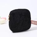 Close-up of black embossed floral canvas pouch with elegant pearl zipper detail - Black