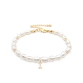 Detailed macro view of baroque freshwater pearls and a gold-plated letter I charm - Letter I