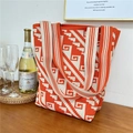 Detail of orange and beige knit tote bag with geometric pattern on a wooden table - 4 Staircase Pattern Orange Beige