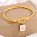 Golden Leo zodiac cable bracelet featuring white square charm on a gift box background - Gold Leo