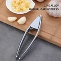 Manual zinc alloy garlic press in silver finish with minced garlic on wooden board - 3502 Model Garlic Press Bag Pack
