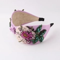 Detail of purple twisted headband with floral embroidery and sparkling rhinestones - Magenta