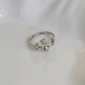 Close-up of silver tulip ring with micro-pave crystals on white wave texture - Silver