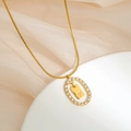 Macro shot of gold oval pendant featuring encrusted rhinestones and the letter F - Letter F