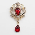 Vintage golden brooch with red teardrop crystal and sparkling rhinestone accents - Red