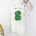 Green dinosaur number 8 birthday candle with white dots and backcard packaging - Number 8