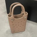 Close-up of khaki EVA tote bag showing breathable hole design and metal rivet details - Brown
