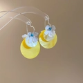 Detalle de pendientes florales con discos de concha amarilla y detalles de perlas - Amarillo