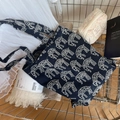 Dettaglio della borsa tote in tela blu con ricami di animali bianchi nel carrello - Blu Notte
