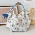 Detail of blue seersucker tote bag featuring vintage bear prints and woven rope handles - Badge Bear