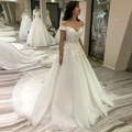 Elegant off-shoulder lace wedding dress with a long tulle train in a classic A-line style - US 2 / White with Train