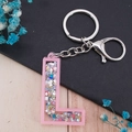 Pink acrylic letter L keychain with colorful star sequins and silver metal ring - Letter L