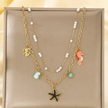 Vista detallada del collar dorado de doble capa con dijes de estrella de mar, caballito y perla - Estilo Caballito de Mar Estrella de Mar Perla (KN292162-SXSJ)