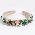 Close-up of luxury Baroque headband featuring green velvet with colorful gems and pearls - Green