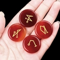 Mano che tiene quattro pietre di agata rossa con simboli di arcangelo dorati su sfondo nero - Set di 4 / Agata rossa