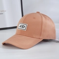 Detailed close-up of light brown baseball cap with embroidered AD patch and cotton texture - Orange + Black Label