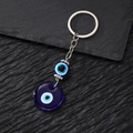 Vintage Böser Blick Schlüsselanhänger mit blauem Glasanhänger und Metallkette auf Stein - Gläsernes Rundes Auge