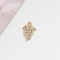 Detailed macro of a gold grape pendant with sparkling cubic zirconia on textured paper - 4# Grape