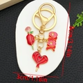 Detail of a 8cm golden keychain with rose, heart lollipop, and XOXO enamel charms - Red Heart Rose Style (ER1281)