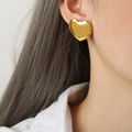 Minimalist large heart stud earrings in polished gold finish worn by a model - Large (F1072) / Gold