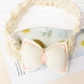 Gros plan détaillé d'un bandeau bébé crème avec un nœud en tissu fait main et dentelle - Abricot