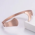 Dettaglio del bracciale rigido oro rosa con mezzaluna e incisione floreale vintage - Oro rosa