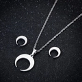 Vue détaillée du parure collier et boucles d'oreilles lune minimaliste sur fond noir - Croissant de Lune (082) / Acier