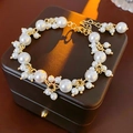 Detailansicht der weißen Perlen und Goldkette mit Herzanhänger auf der Lederbox - Weiß