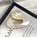 Close-up of beige acetate irregular heart hair claw clip with golden metal teeth - Irregular Mermaid White