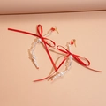 Detalle de pendientes de lazo de satén rojo con borlas de perlas y cristal brillante - Rojo