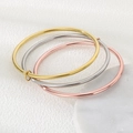 Drei ineinandergreifende Armreifen in Gold, Silber und Roségold auf Marmor - 55mm / Dreifachringe (Gold + Stahl + Roségold)