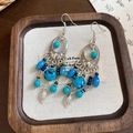 Detailed close-up of retro bohemian earrings with turquoise beads and leaf tassels on a tray - Ear Hook Tassel Leaf Style / Blue