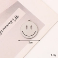 Macro shot of a 2cm silver smiley face charm for DIY necklaces and jewelry making - C340 20mm Silver Hollow Smiley