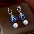 Detail of vintage teardrop earrings featuring blue crystals and a large white pearl drop - Silver Pin-Silver-Blue-White