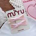 Close-up of pink ribbon bow hair clips on a display card with elegant lace background - Light Pink