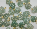 Detailed view of handmade green heart pendants with gold wire wrapping craftmanship - Natural Green Aventurine