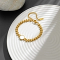 Elegante pulsera de acero de titanio dorado con eslabones de corazón y nácar blanco - Estilo Redondo (M803)