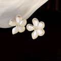 Nahaufnahme minimalistischer, mattweißer Blumenohrstecker auf dunklem Grund - Silberne Blume (925 Silberstift)