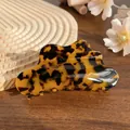 Elegant tortoise shell claw clip in acetate with dark amber pattern on a wooden surface - Coffee Tortoise Shell