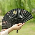 Chinese folding fan with gold crane and moon motif on black fabric with tassel - Crane in Pavilion Black Handle