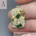 Close-up of rectangle gold pendant with green gems, skull design, 16.5x28.4mm size details - A-Rectangle Skull