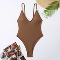 Flat lay view of a dark brown deep V-neck one-piece swimsuit with summer vacation accessories - Brown
