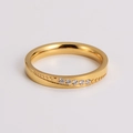 Primer plano de un anillo dorado con seis circonitas y un elegante grabado curvado - US 6 / Dorado