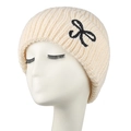 Dettaglio del berretto in maglia bianco crema con ricamo a fiocco nero e trama a coste - Beige