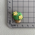 Vue détaillée d'une breloque pot de fleur en résine de 2cm sur tapis gradué - 13*Un pot de camélia
