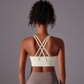 Dettaglio posteriore di un reggiseno sportivo crema con spalline incrociate per lo yoga - Taglia S / Top / Avorio chiaro