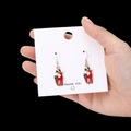 Cute red and gold reindeer drop earrings for Christmas, shown held on a card for scale - Red Reindeer Enamel