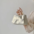 Detail view of the white pleated cloud bag featuring a luxury pearl handle and soft leather - White